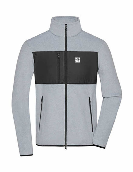 A lightgrey Jacket with a embroided "HDNBRG Trails" Emblem on the left Chest.